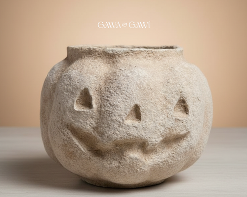 Decorative stone pumpkin with a face on a beige background, featuring the brand 'GAWA GAWI'.